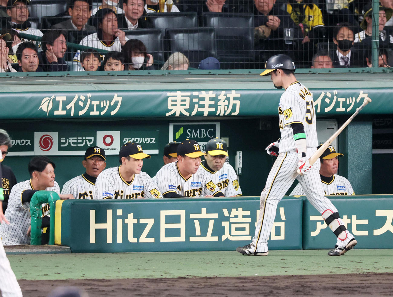 阪神対オリックス　9回裏阪神1死二塁、三振してベンチへ戻る中野の奥でグラウンドを見つめる岡田監督（撮影・加藤哉）