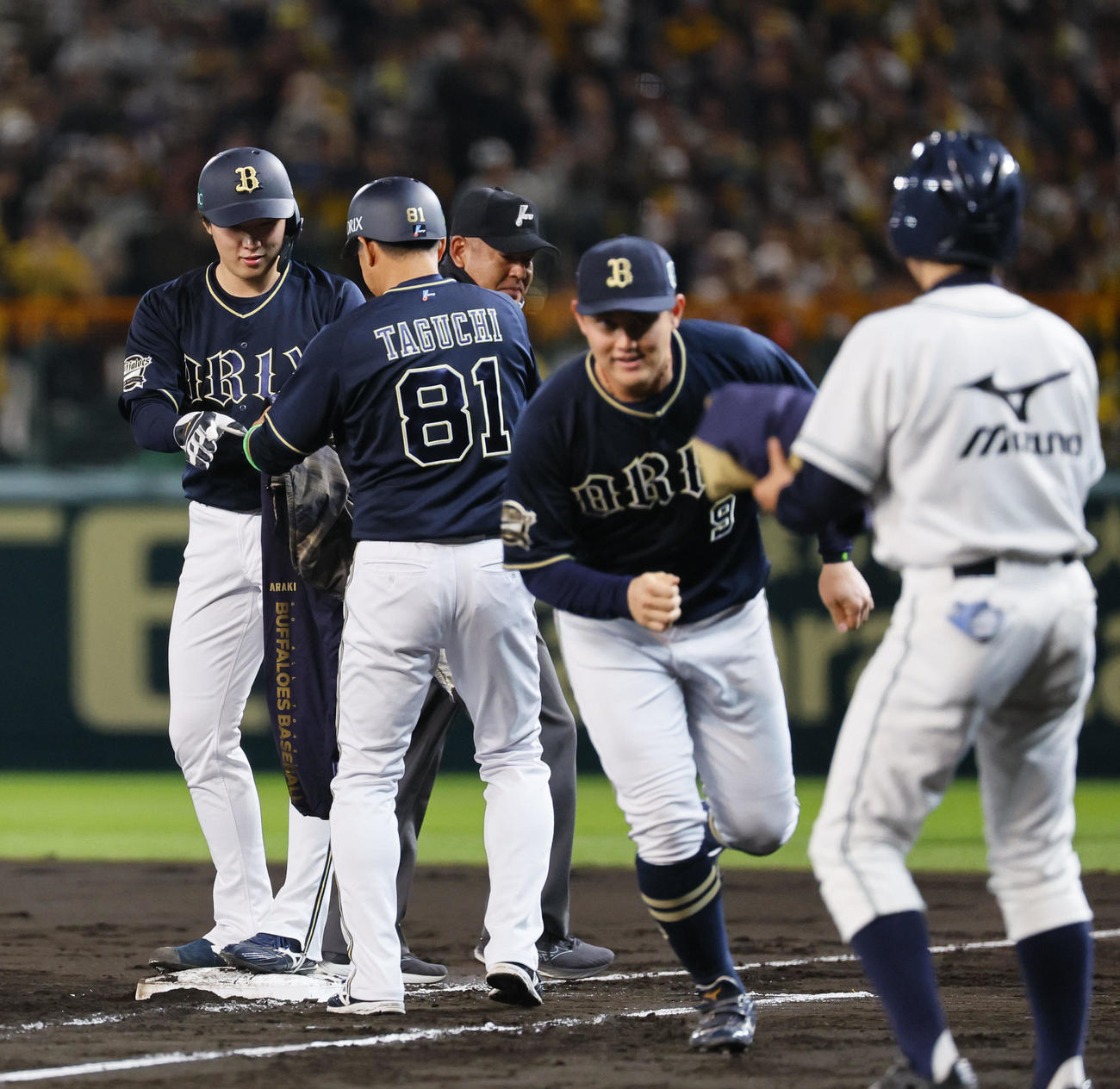 阪神対オリックス　5回表オリックス1死一、二塁、ウインドブレーカーを受け取る一塁走者東（左）（撮影・藤尾明華）