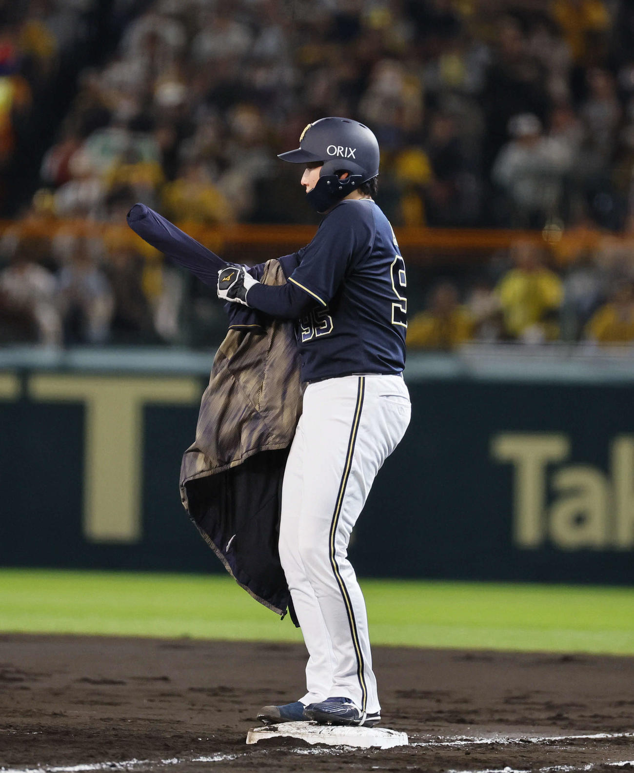 阪神対オリックス　5回表オリックス1死一、二塁、東は一塁ベース上で上着に袖を通すも手が出ずに結局諦める（撮影・藤尾明華）