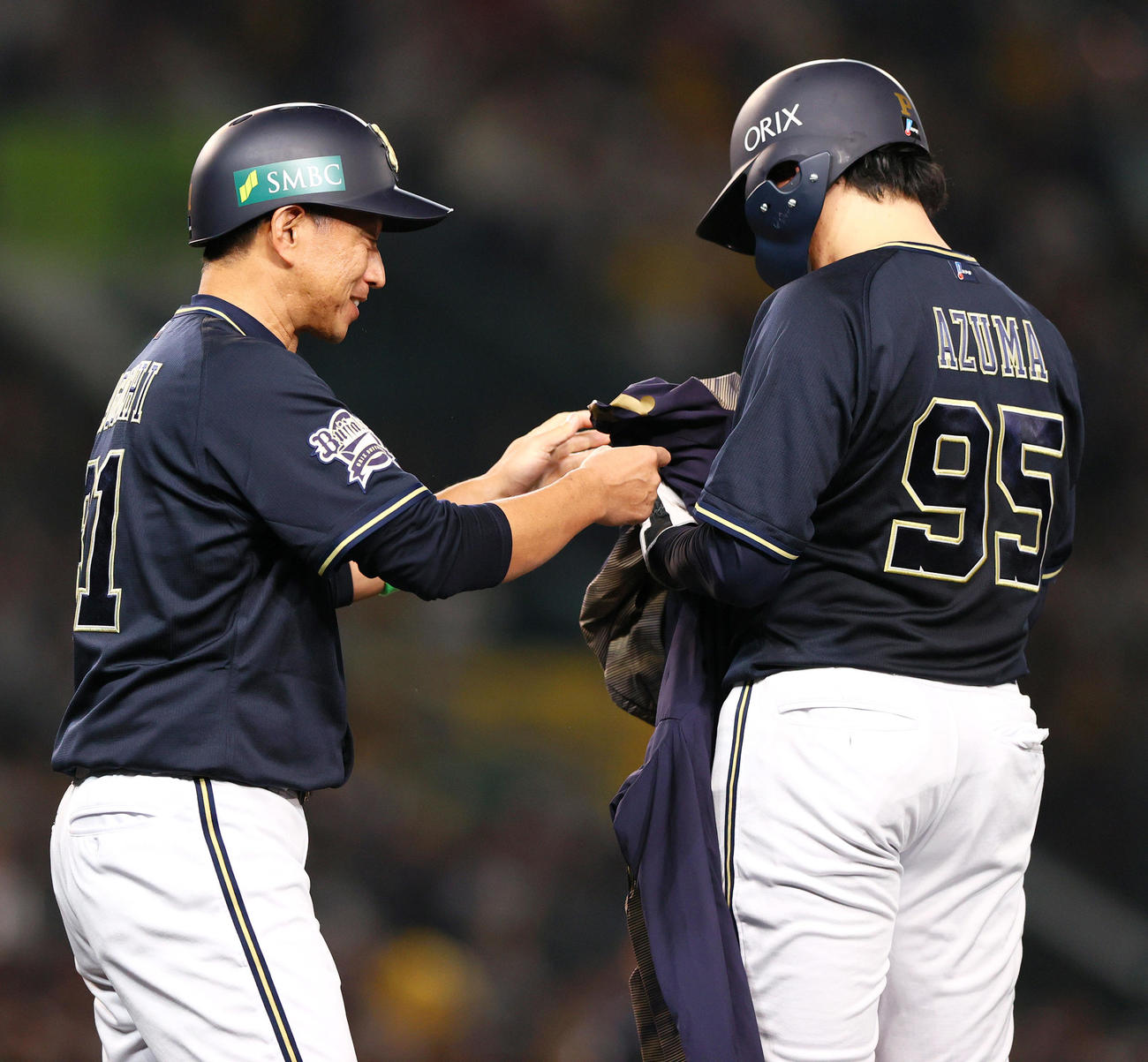 阪神対オリックス　5回表オリックス1死一塁、東晃平（右）はバント悪送球で出塁し、田口壮外野守備・走塁コーチから上着を受け取るが着用出来ず（撮影・上山淳一）