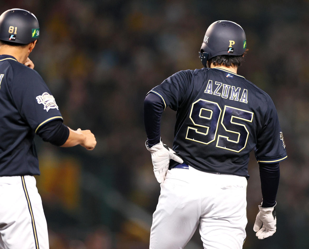 阪神対オリックス　5回表オリックス1死一塁、東晃平（右）はバント悪送球で出塁し、田口壮外野守備・走塁コーチから上着を受け取るが着用出来ず（撮影・上山淳一）
