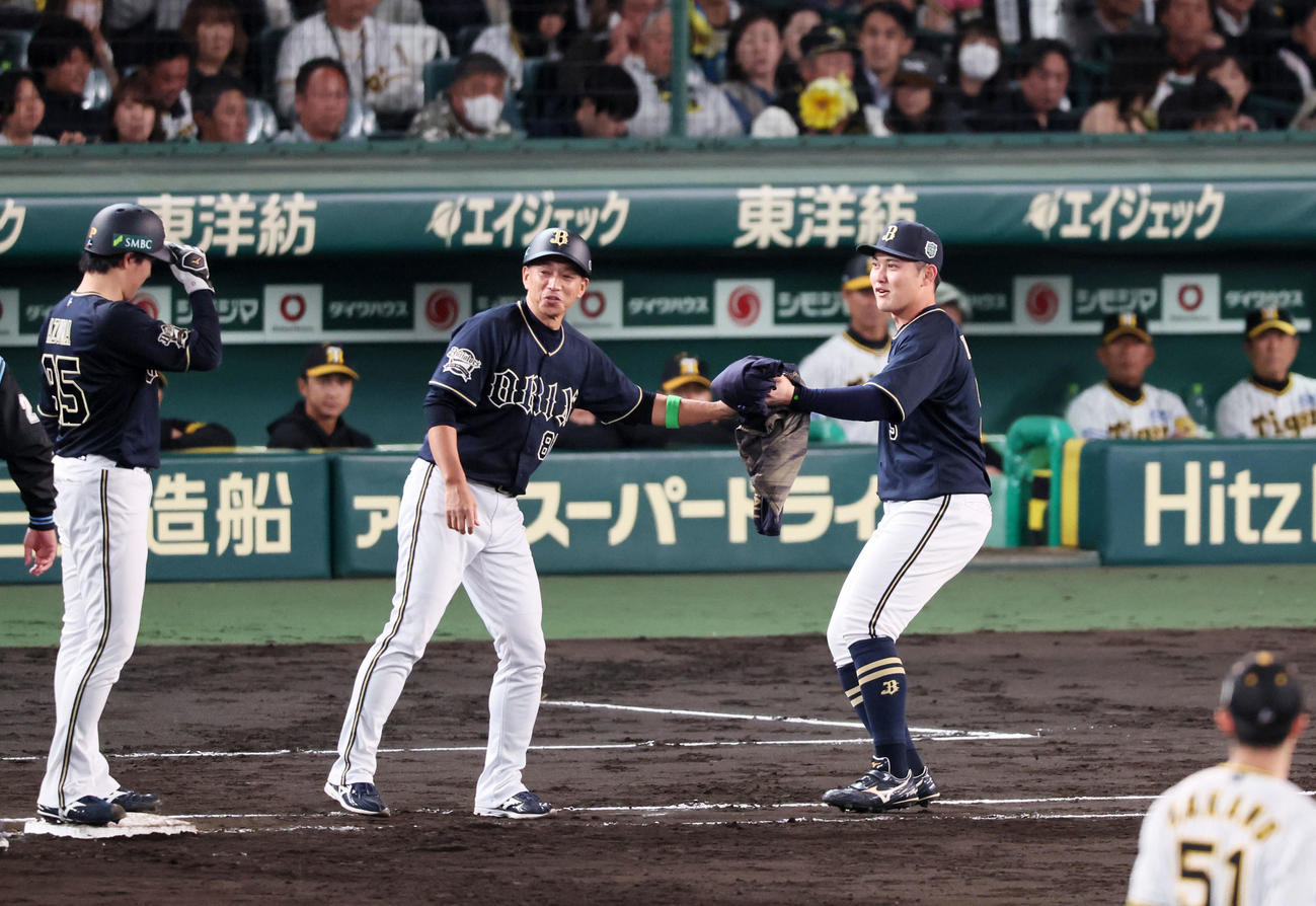 阪神対オリックス　5回表オリックス1死一塁、東（左）は犠打を決め一塁走者となり上着を野口（右）が運んできたが…（撮影・加藤哉）