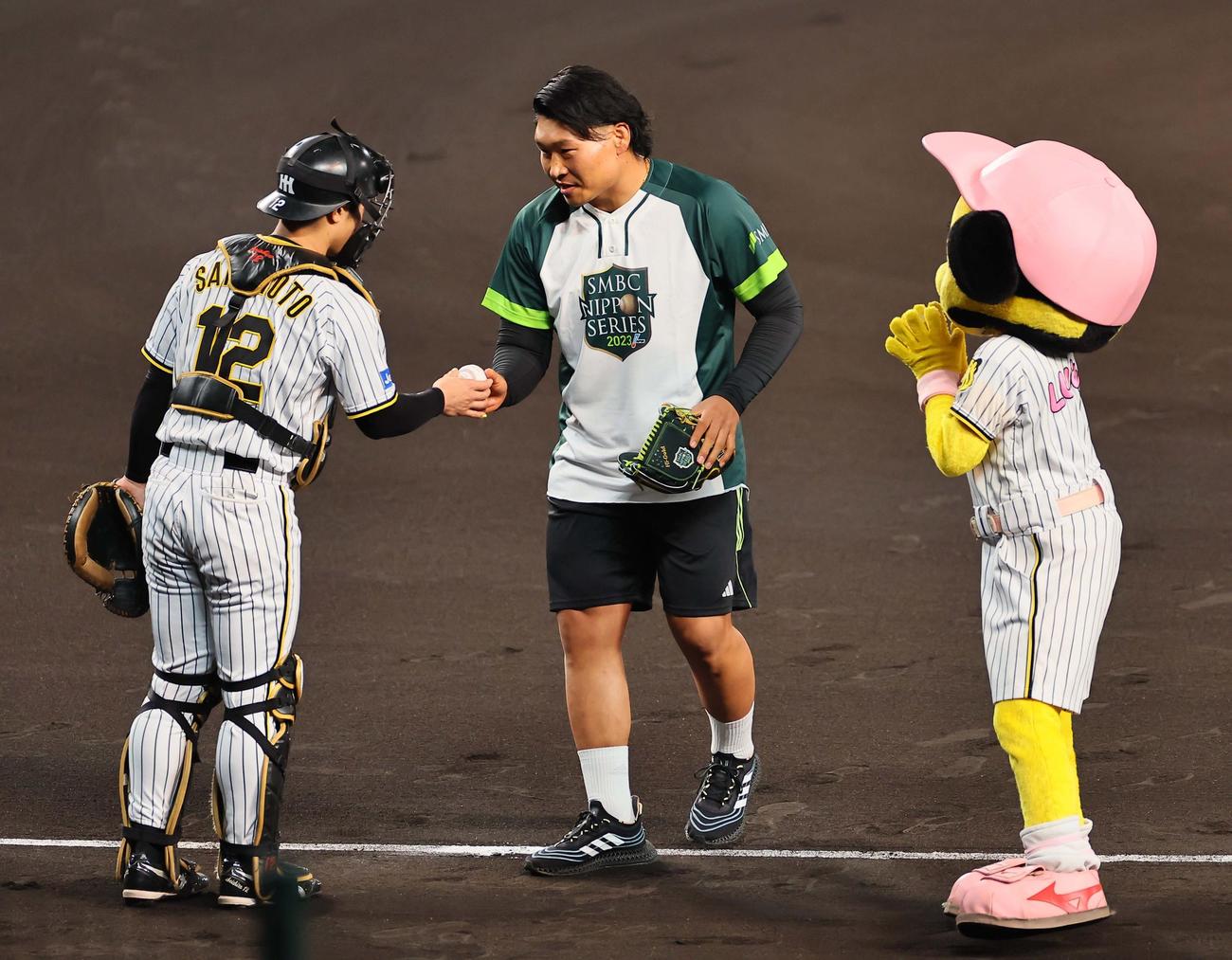 日本シリーズ第4戦　阪神対オリックス　始球式をつとめたラグビー日本代表・稲垣（中央）は坂本からボールを受け取る（撮影・上田博志）