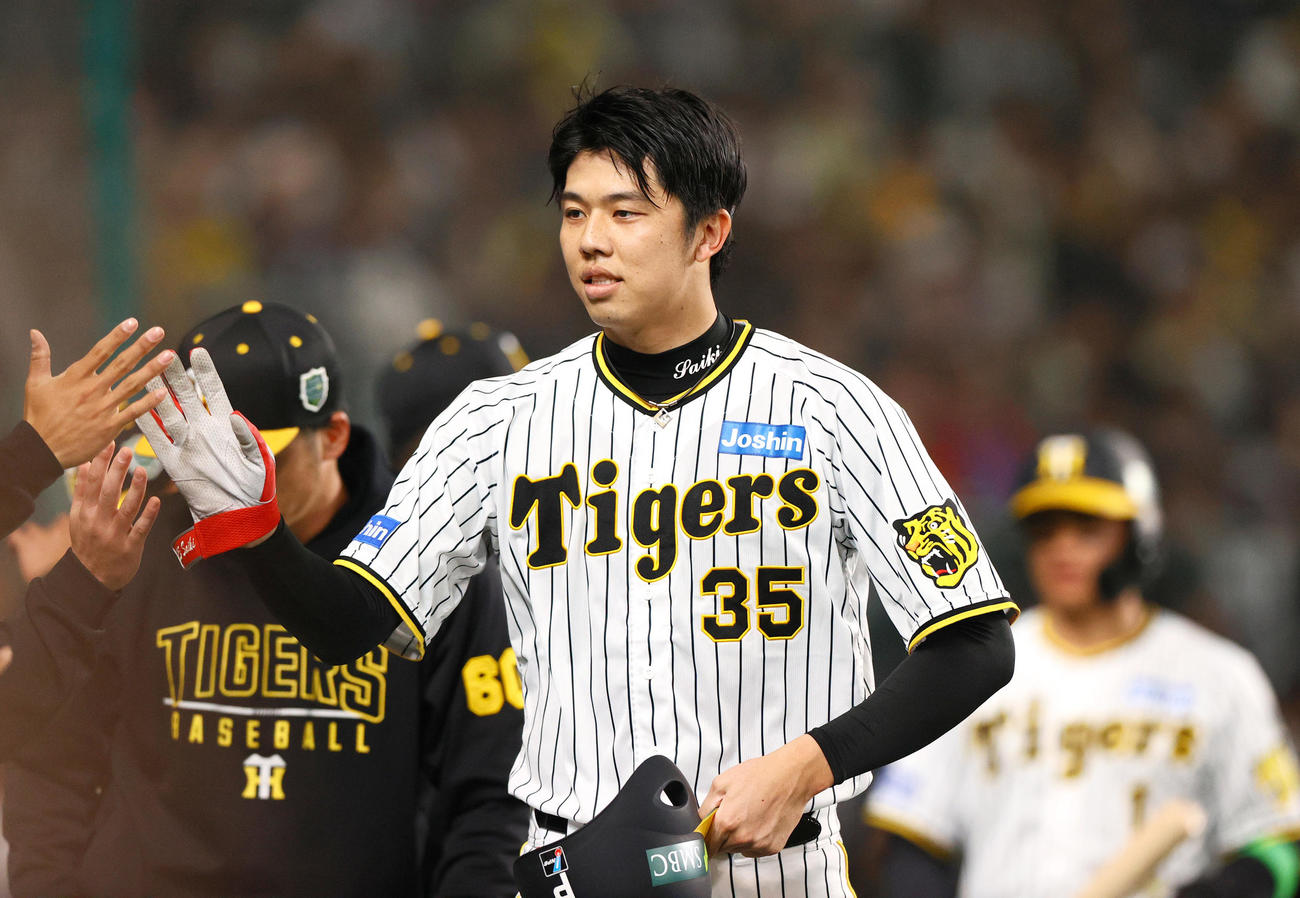 阪神対オリックス　2回裏を終え、ベンチでナインとタッチをかわす阪神才木（撮影・上山淳一）