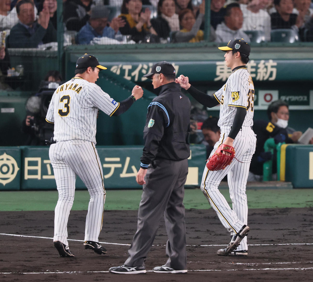 阪神対オリックス　5回表オリックス2死、才木は頓宮を一邪飛に仕留め大山悠輔（左）とタッチする（撮影・加藤哉）