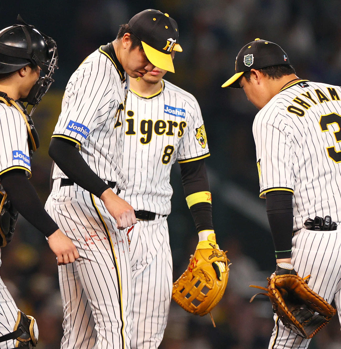 阪神対オリックス　2回表、右手からの流血をふいたユニホームが赤く染まる阪神才木（左から2人目）（撮影・上山淳一）