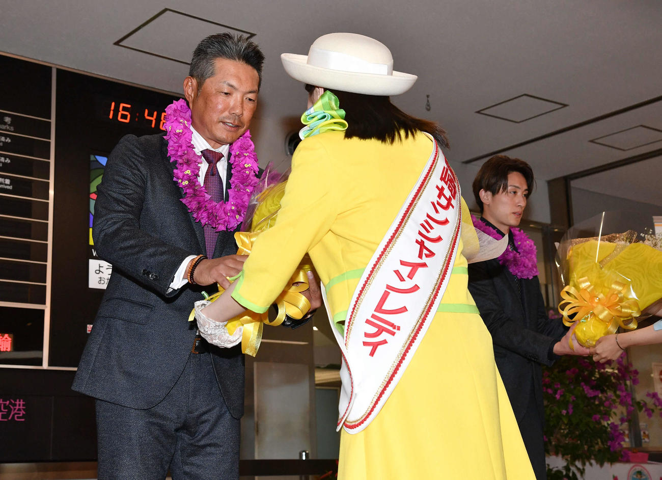 宮崎空港に到着し、歓迎セレモニーで花束を贈呈される小久保監督（左）と周東（撮影・岩下翔太）