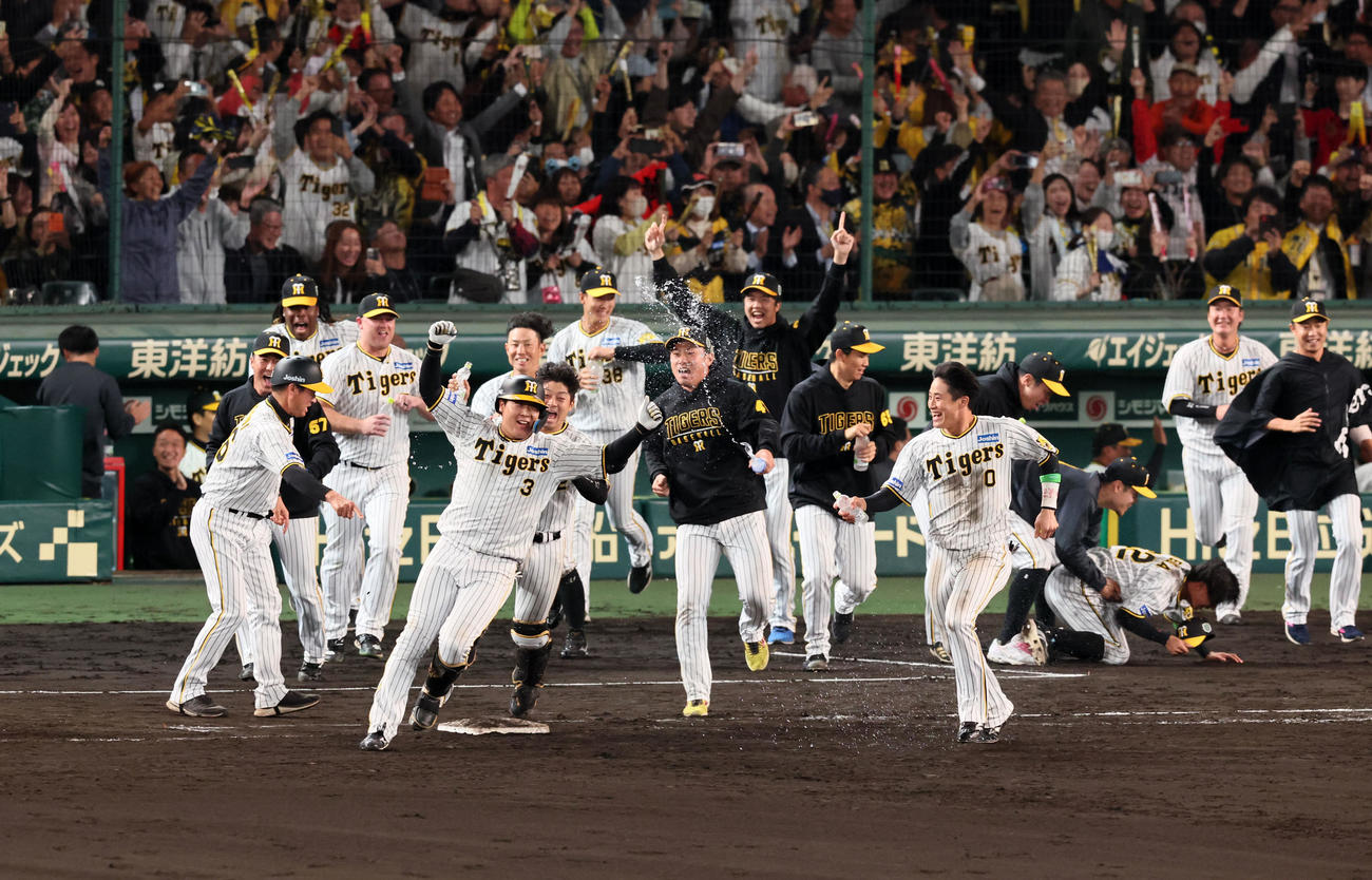 阪神対オリックス　9回裏阪神1死満塁、大山は左へサヨナラ適時打を放ち歓喜するナインから水を掛けられる（撮影・加藤哉）