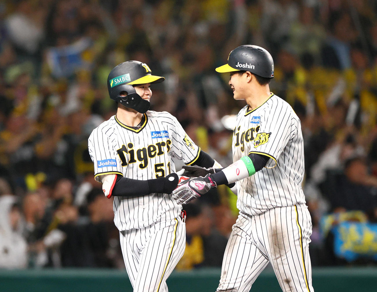 阪神対オリックス　2回裏阪神2死一、二塁、木浪（右）は近本の左前適時打で生還、中野から祝福される（撮影・上山淳一）