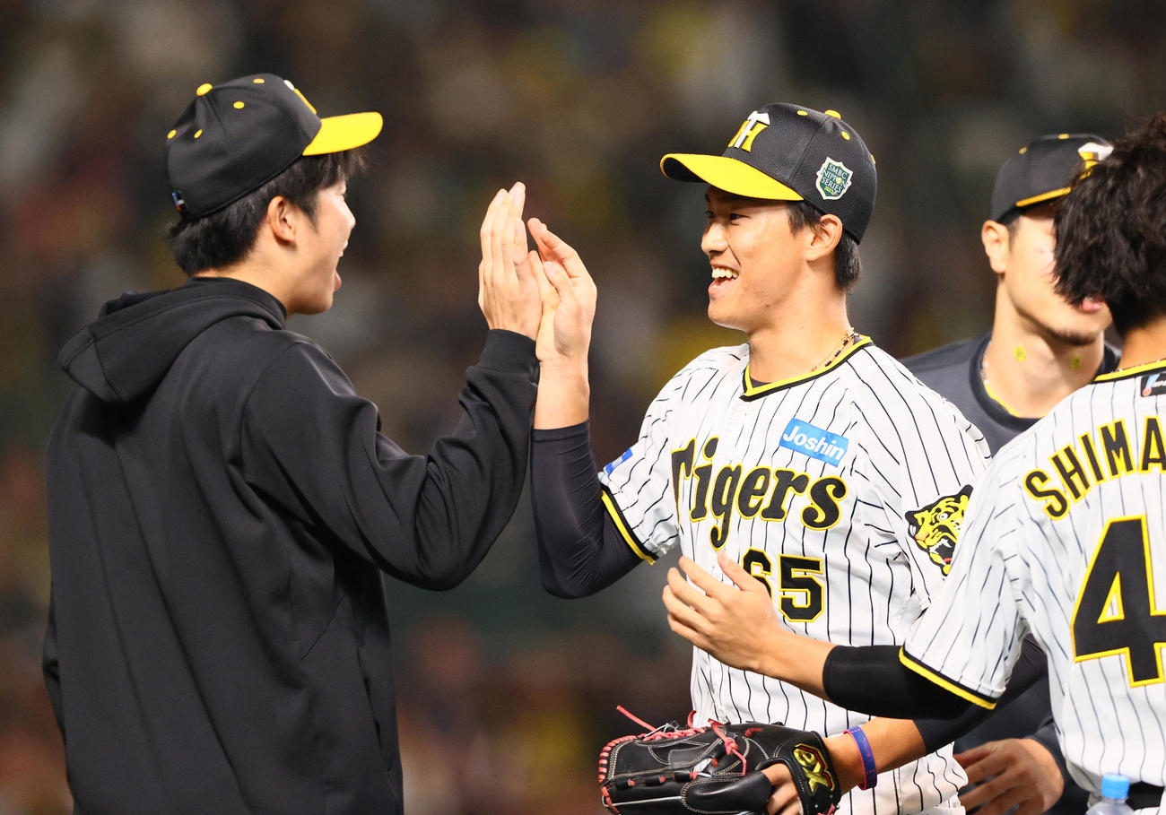阪神対オリックス　8回表オリックス2死一、三塁、湯浅（左から2人目）は中川圭を二飛に仕留め、ベンチ前で才木とハイタッチする（撮影・上山淳一）