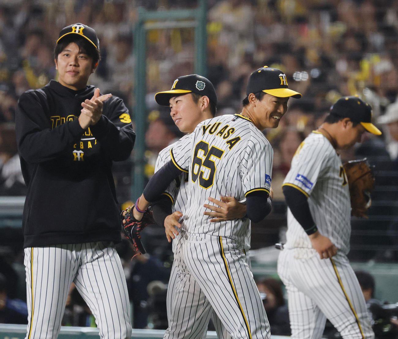 阪神対オリックス　8回、ピンチを切り抜け、石井と笑顔で抱き合う阪神湯浅（中央右）（撮影・藤尾明華）