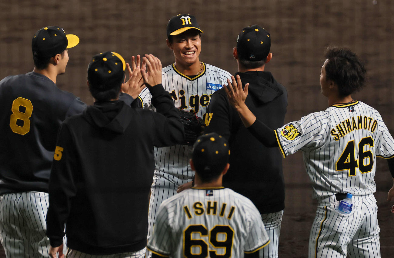 戦　阪神対オリックス　8回表オリックス2死一、三塁、中川圭を二飛に打ち取った湯浅（中央）はナインの出迎えに笑顔を見せる（撮影・上田博志）