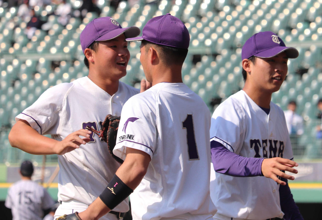 7回無失点に抑えた本間悠貴（中央）と4安打5打点を挙げた天理大の近藤遼一（左）は笑顔でタッチ（撮影・中島麗）