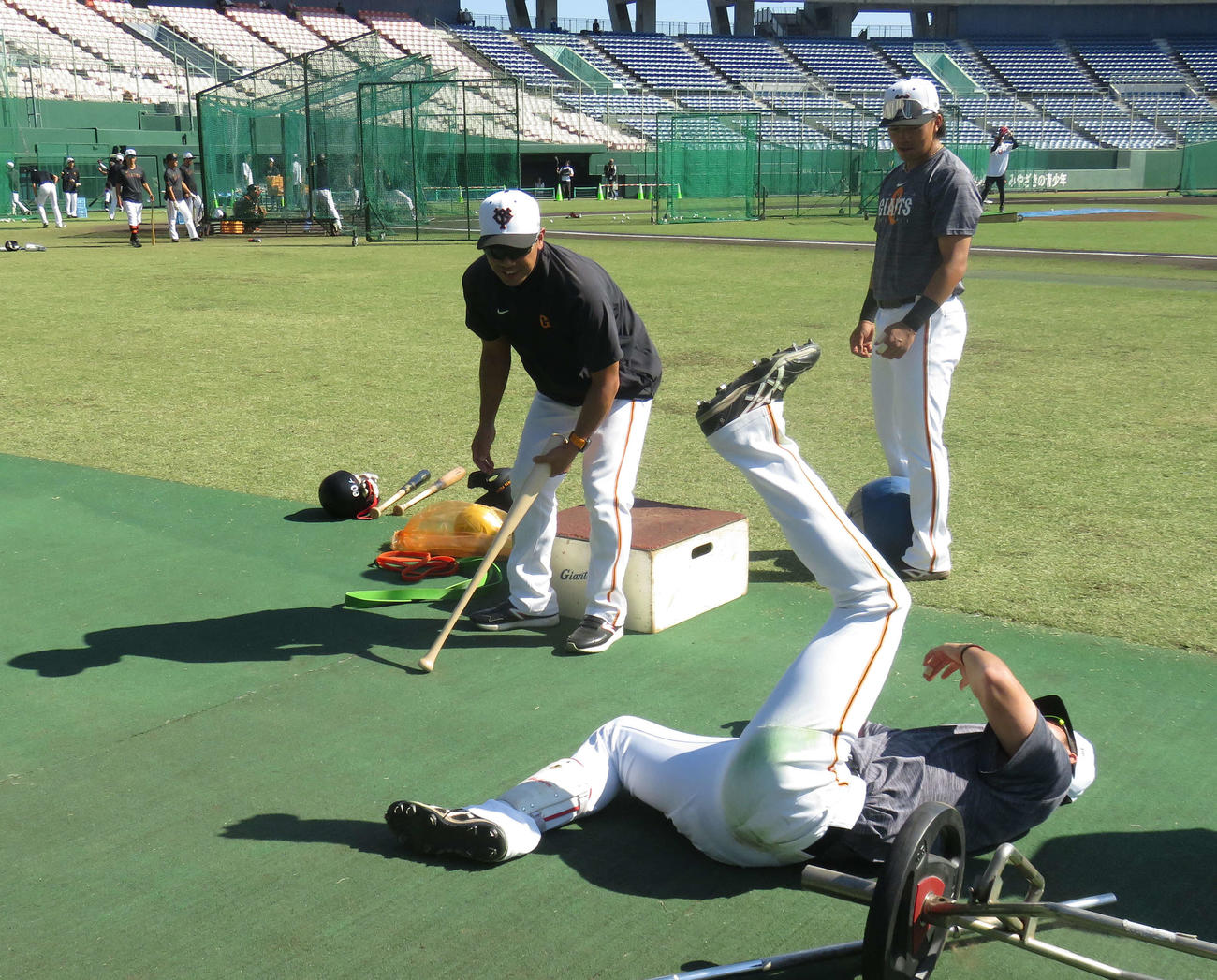巨人阿部新監督（左）から下半身トレーニングで追い込まれもん絶する秋広（手前）。右奥は菊田