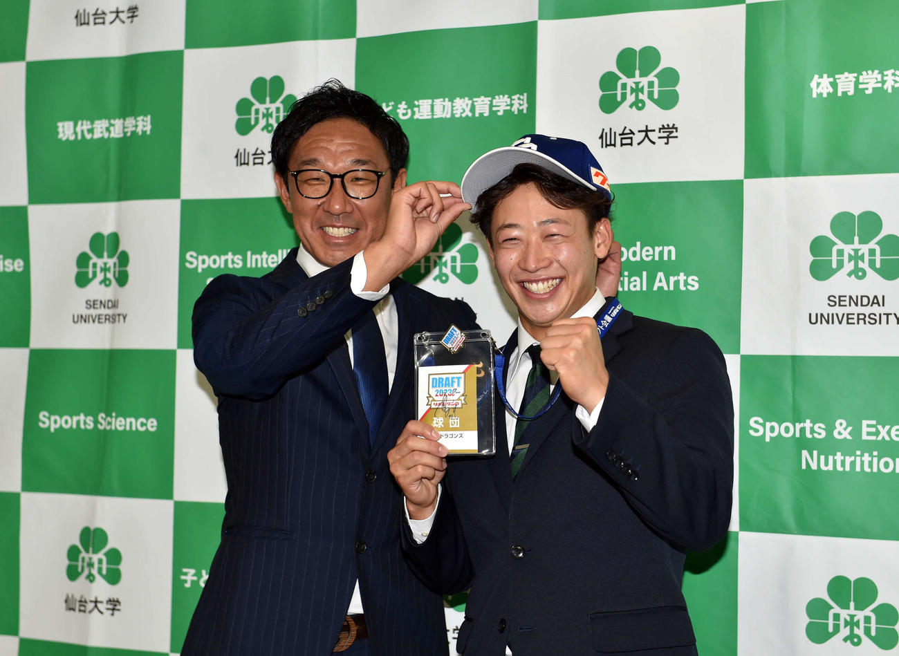 中日八木スカウト（左）から帽子をかぶせてもらう仙台大・辻本（撮影・相沢孔志）