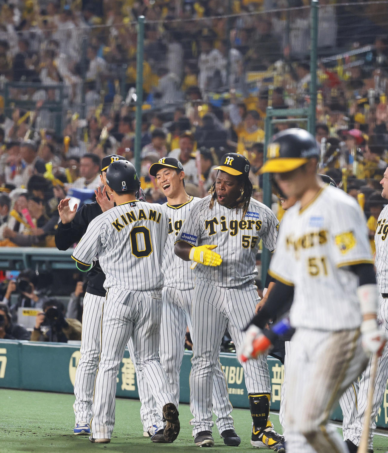 阪神対オリックス　8回裏阪神無死一、三塁、近本光司に右前適時打で生還した木浪を出迎える湯浅（左から3人目）ら阪神ナイン（撮影・藤尾明華）