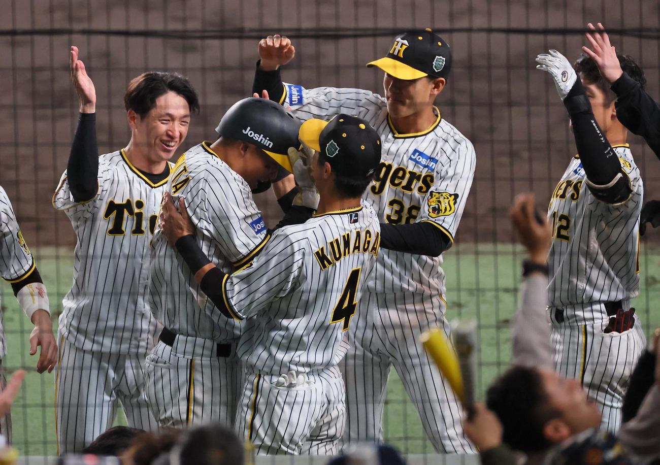 日本シリーズ第5戦　阪神対オリックス　8回裏阪神1死三塁、大山の適時打で生還した森下はナインから手荒い祝福を受ける（撮影・上田博志）