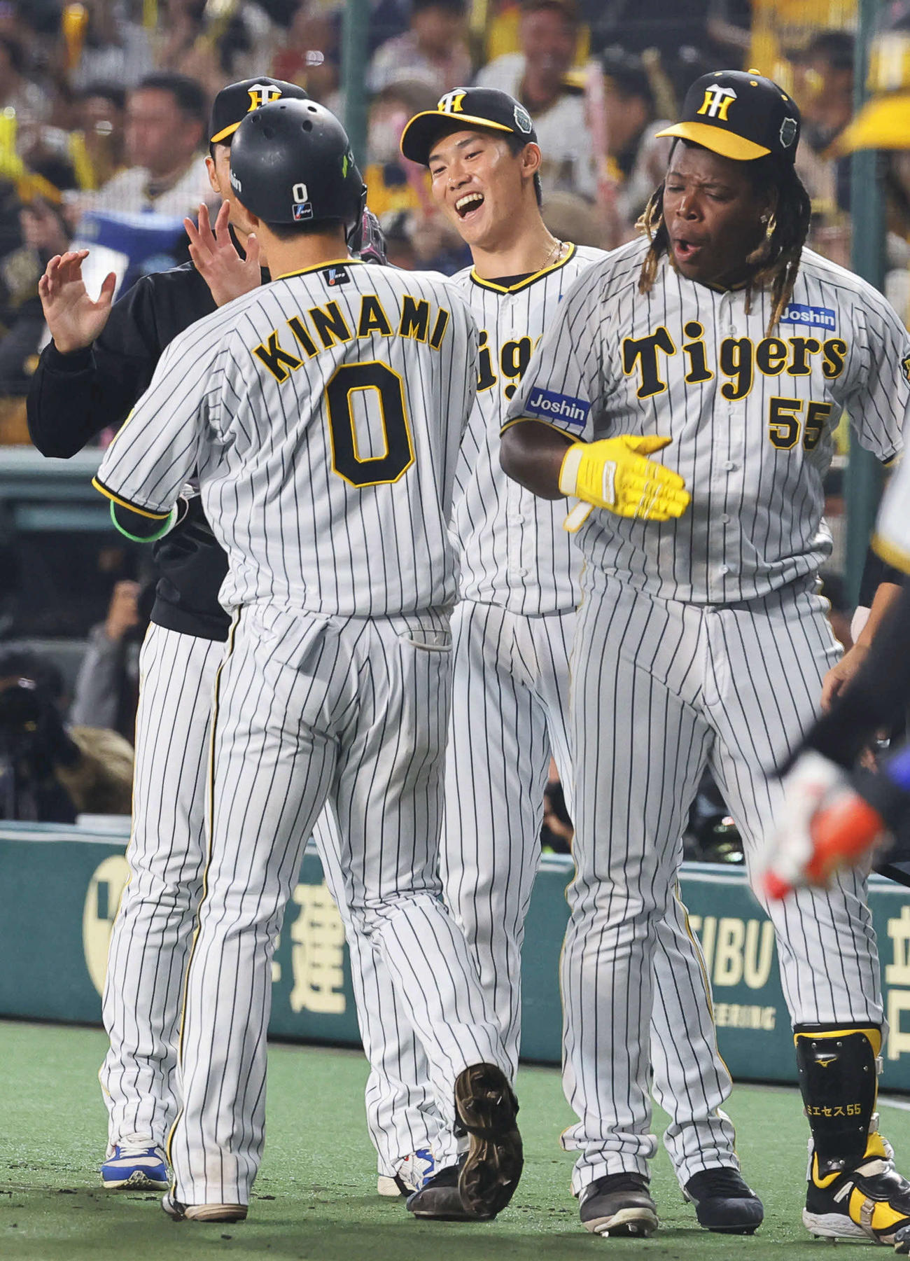 阪神対オリックス　8回裏阪神無死一、三塁、近本の適時打で生還した木浪（左）を出迎える湯浅（中央）ら（撮影・藤尾明華）