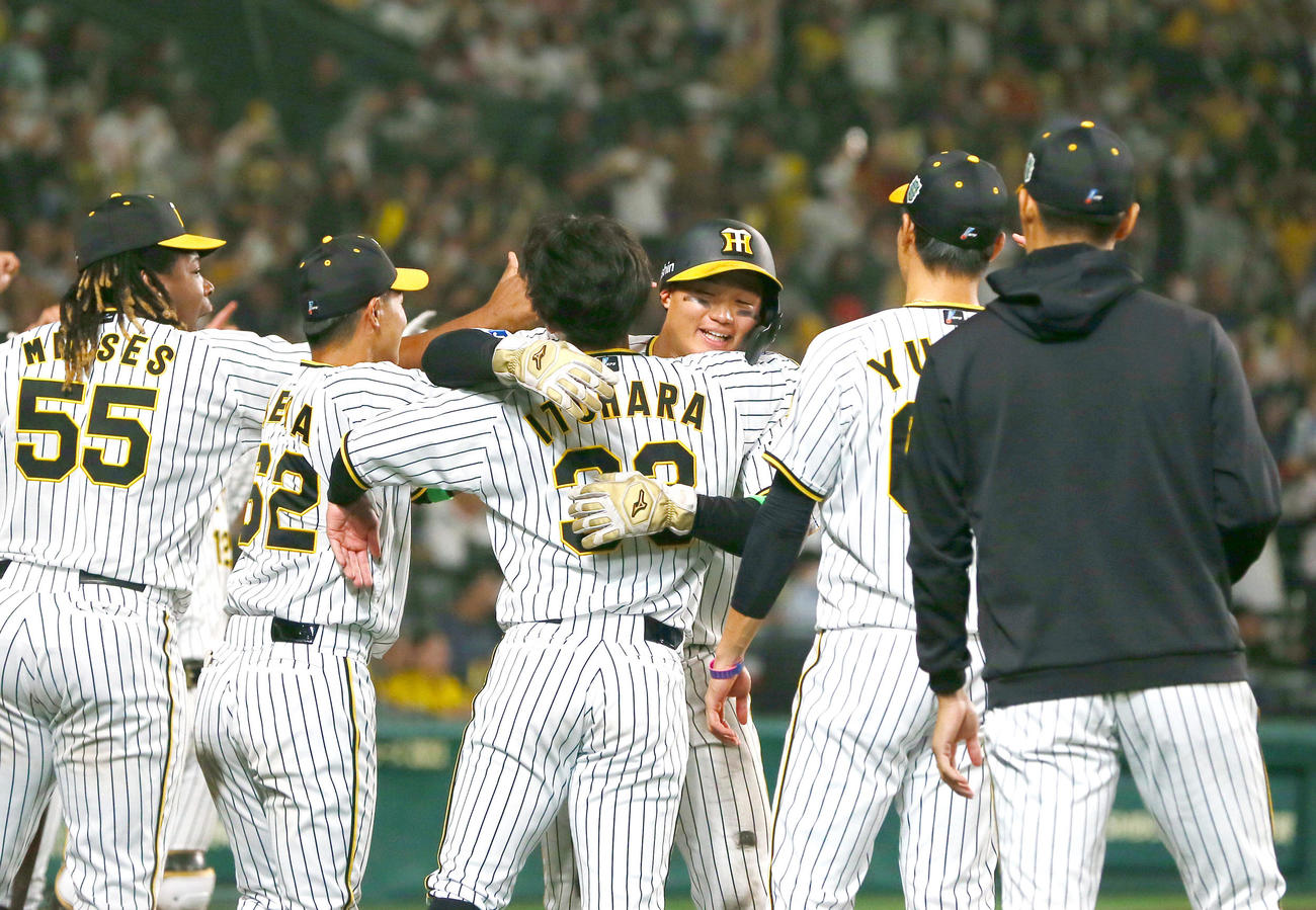 阪神対オリックス　8回裏阪神1死三塁、大山の中前適時打で生還した森下（左から4人目）はナインから祝福される（撮影・上山淳一）