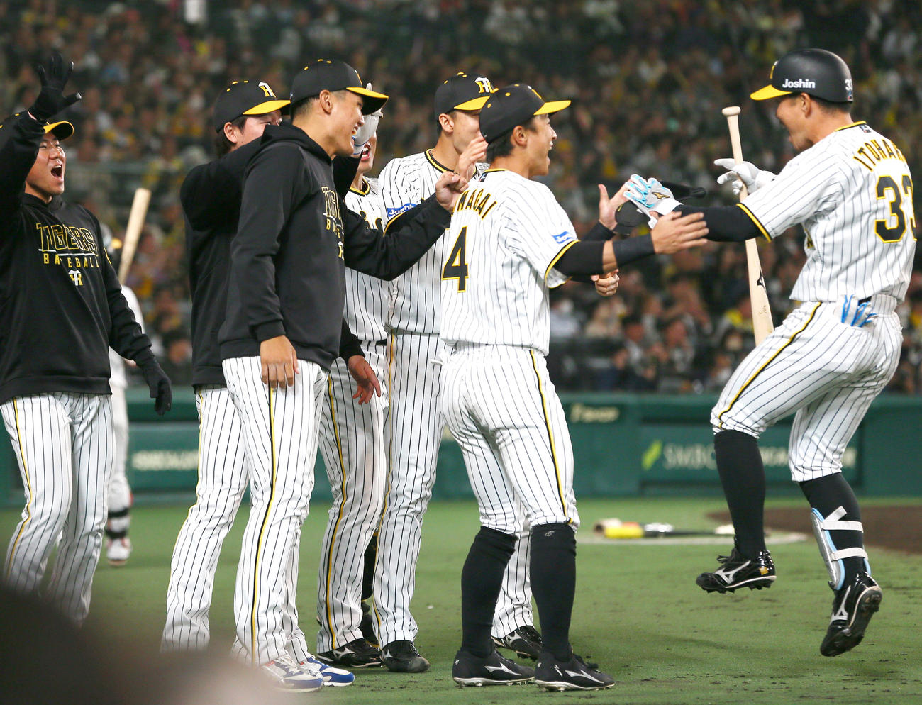阪神対オリックス　8回裏阪神無死二塁、代打糸原（右）は左前打を放ち交代となりナインの出迎えを受ける（撮影・上山淳一）