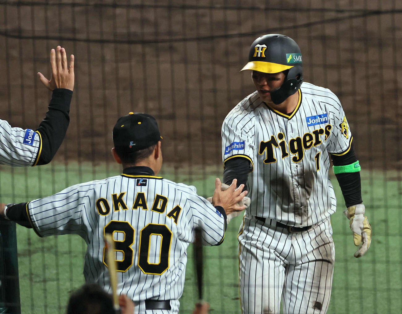 阪神対オリックス　8回裏阪神1死三塁、大山の適時打で生還した森下（右）は岡田監督とタッチを交わす（撮影・上田博志）