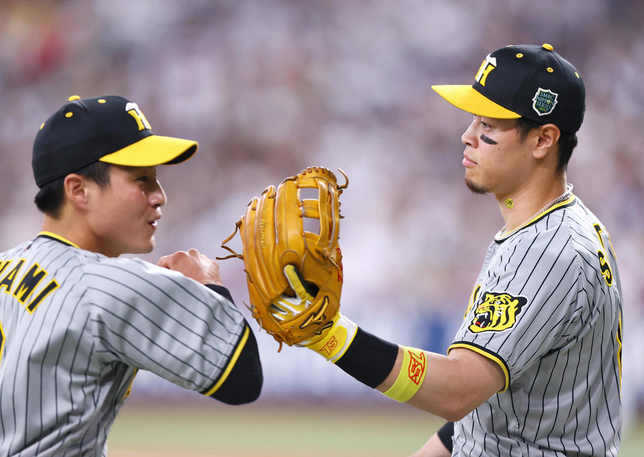 オリックス対阪神　1回裏オリックス2死一、三塁、頓宮の遊直を好捕した木浪（左）とタッチをかわす佐藤輝（撮影・上山淳一）