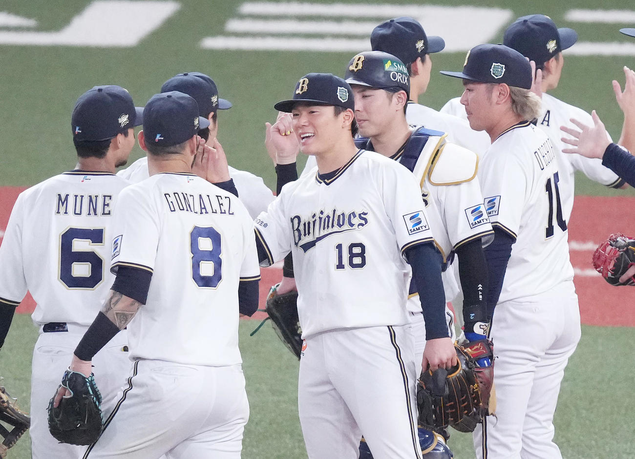 オリックス対阪神　完投勝利で日本一に逆王手をかけ、笑顔でナインとタッチをする山本（中央）（撮影・菅敏）