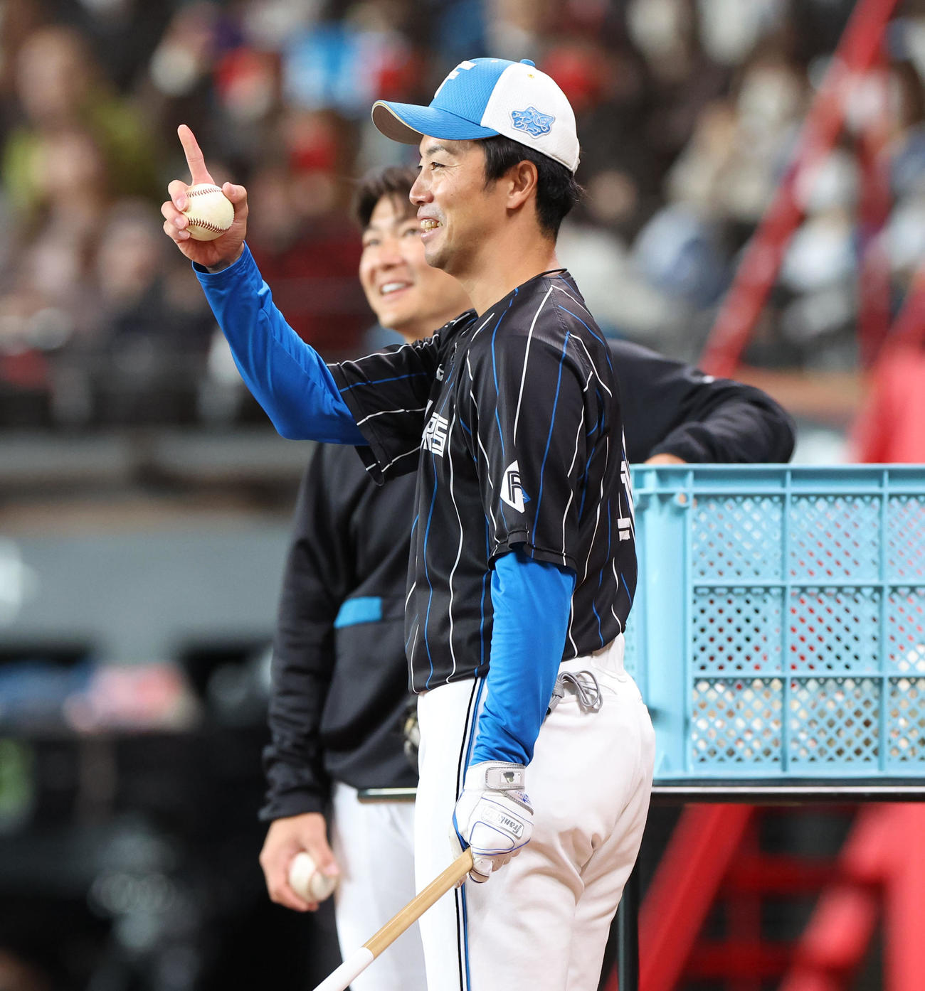 笑顔でアメリカンノックをする日本ハム谷内コーチ（撮影・佐藤翔太）