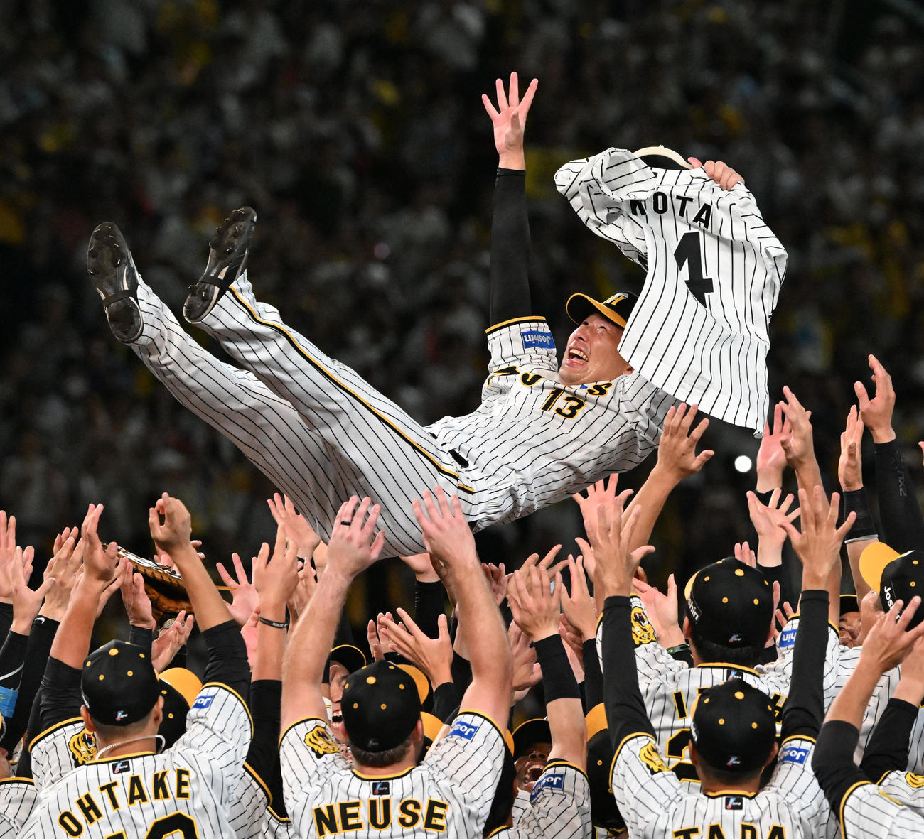 9月14日、リーグ優勝を決め横田慎太郎さんのユニホームを手に胴上げされる岩崎