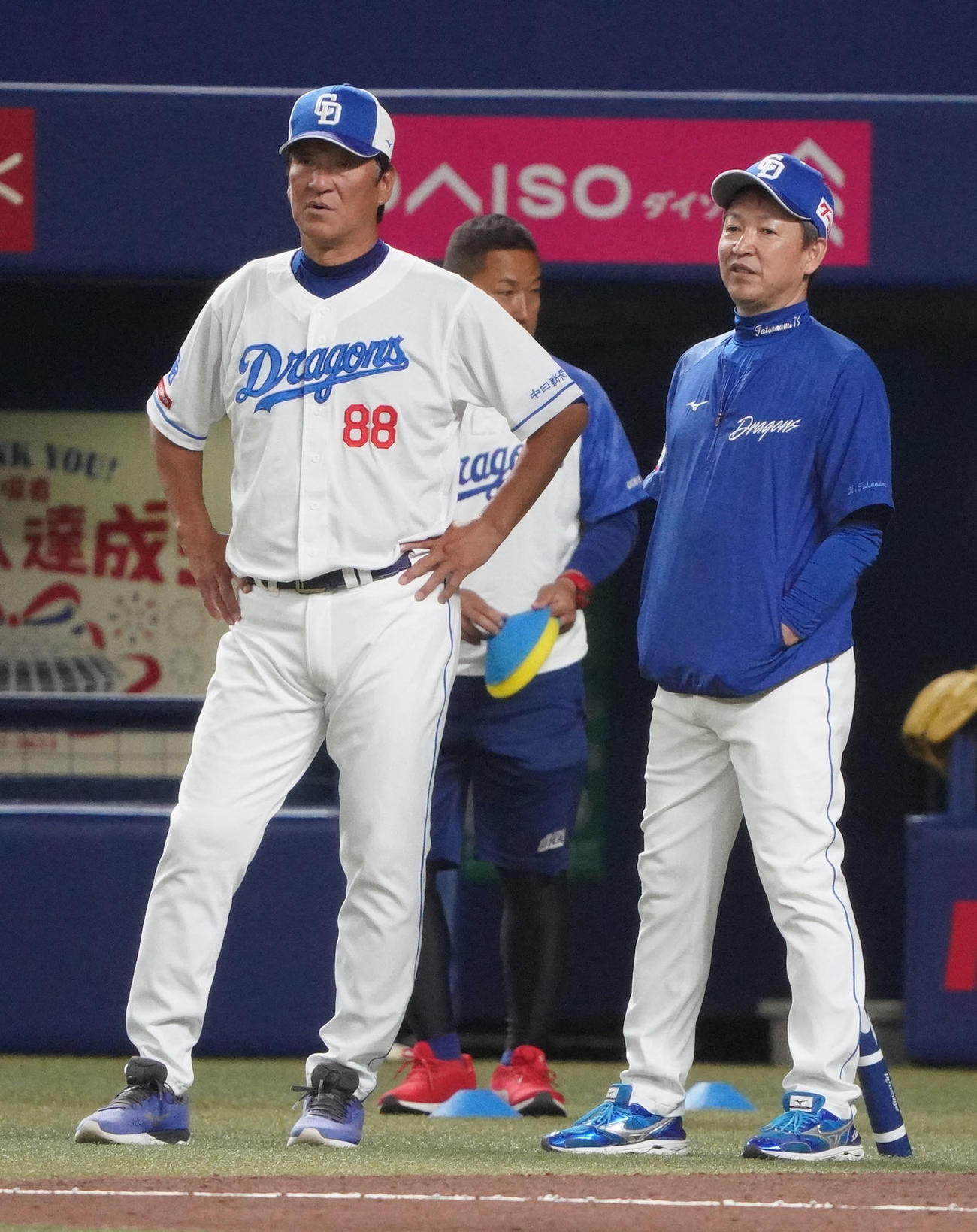片岡ヘッドコーチと言葉を交わしながら練習を見つめる立浪監督（右）（撮影・森本幸一）