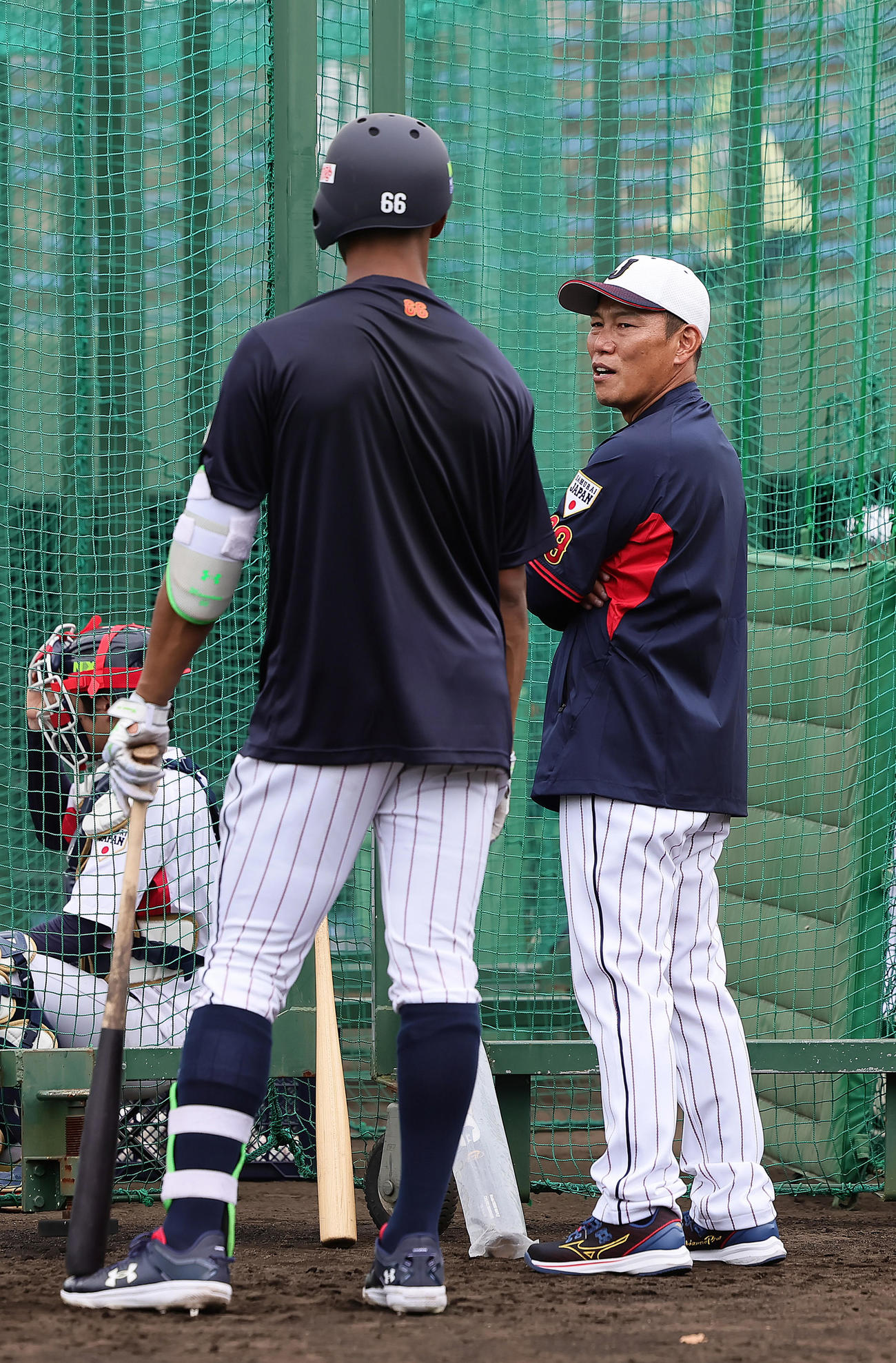 打撃練習中の万波（左）に声をかける井端監督（撮影・足立雅史）