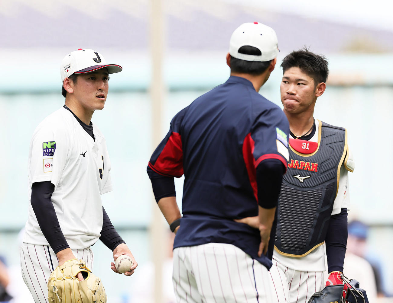 ブルペン投球を終えた隅田（左）は吉見投手コーチ（中央）、坂倉と会話を交わす（撮影・足立雅史）