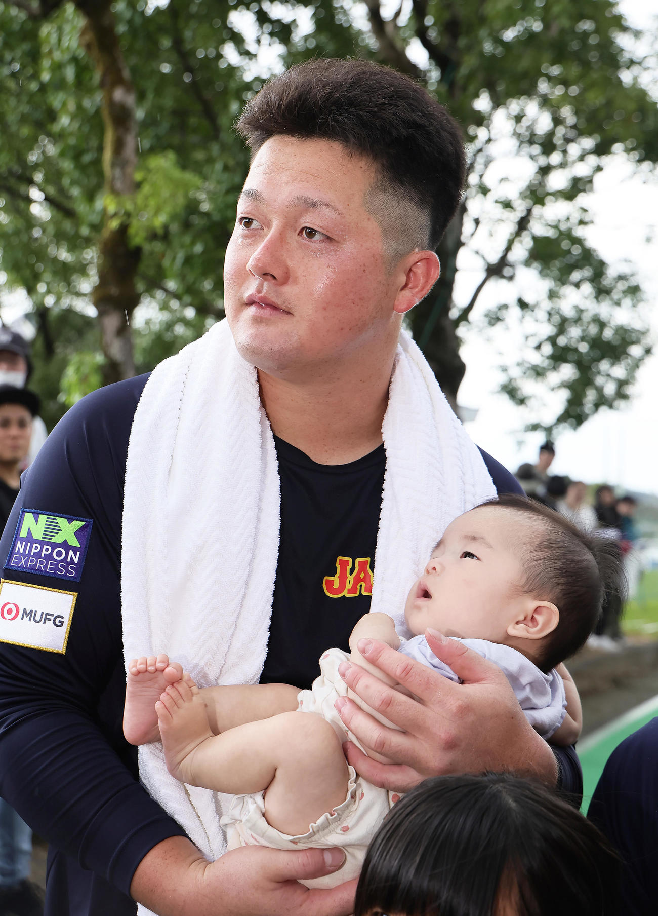 ファンの赤ちゃんを抱っこするDeNA牧（撮影・足立雅史）