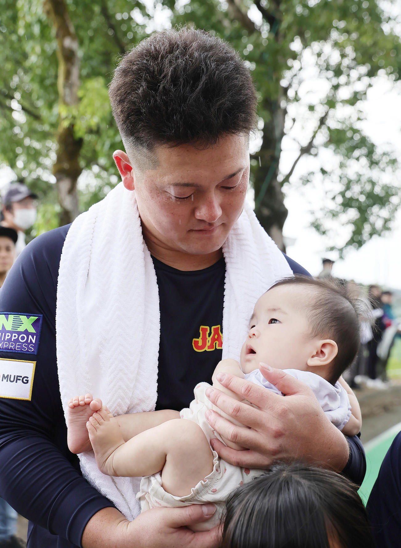ファンの赤ちゃんを抱っこする牧（撮影・足立雅史）