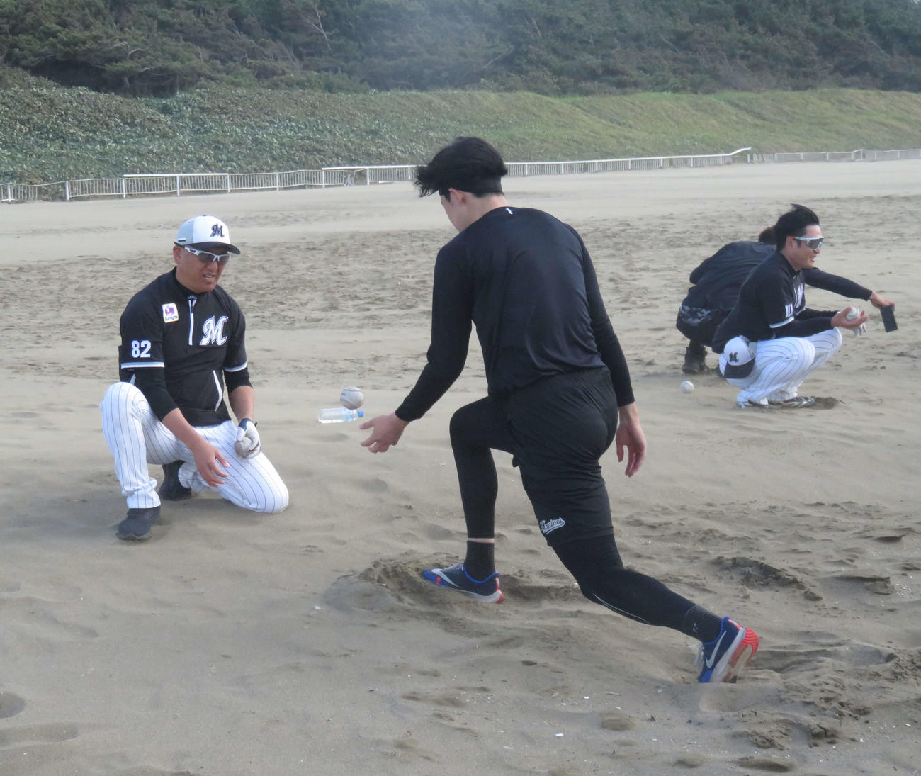 砂浜でトスされたボールをキャッチするロッテ佐々木朗