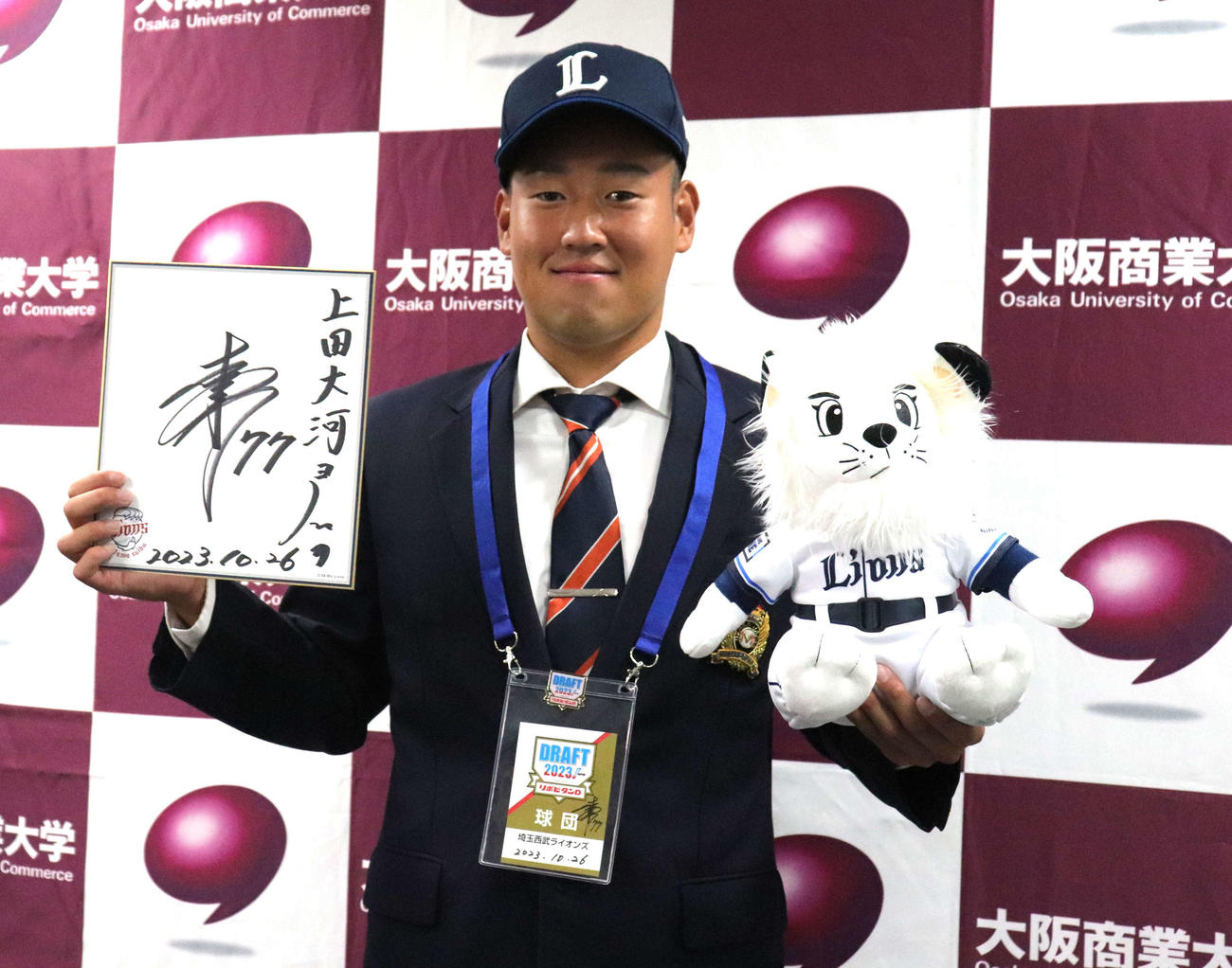 松井監督の色紙を手に笑顔を浮かべる西武ドラフト2位の大商大・上田大河（撮影・中島麗）