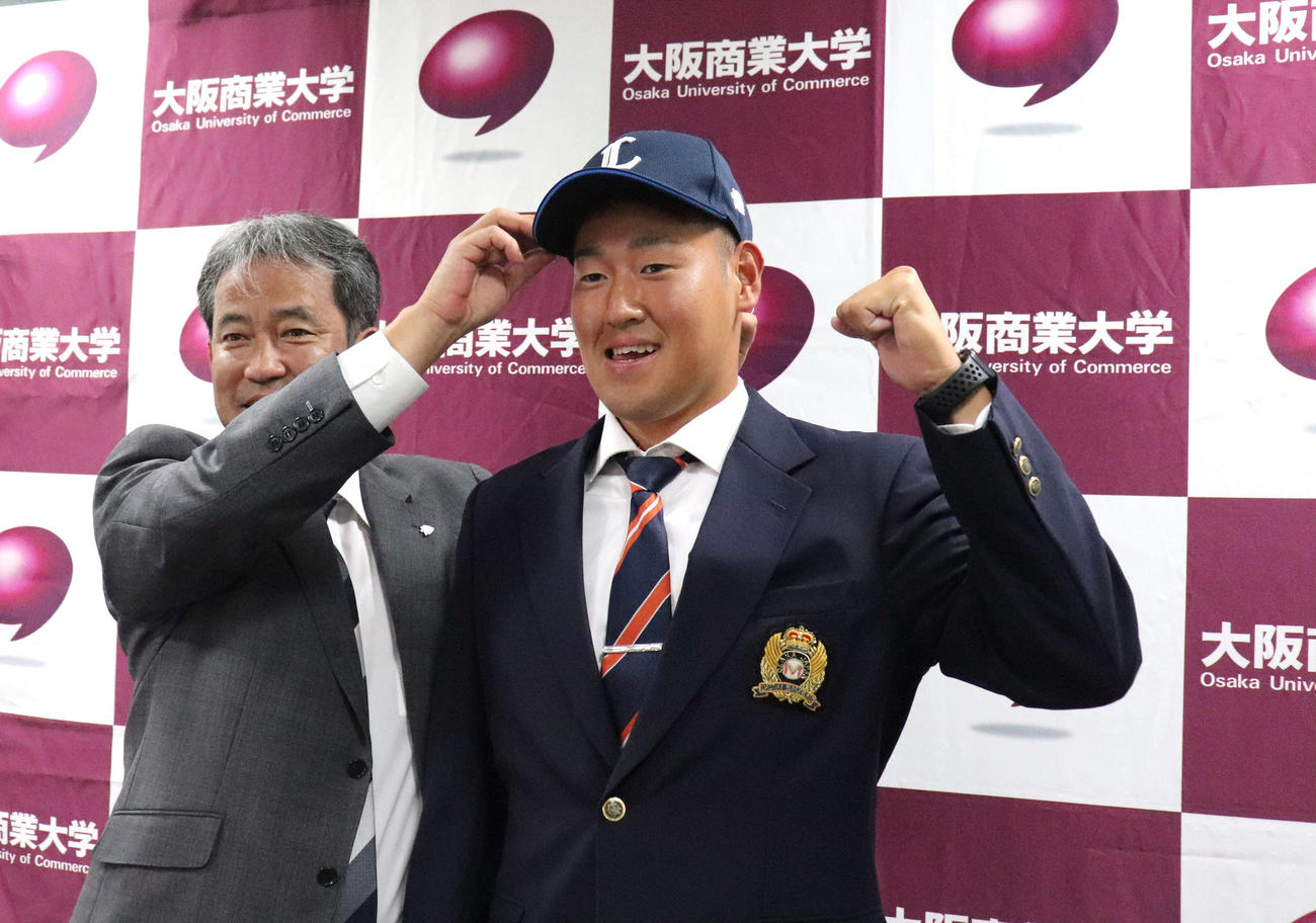 編成グループディレクターの潮崎哲也氏とはじける笑顔を見せた、西武ドラフト2位の大商大・上田大河（撮影・中島麗）