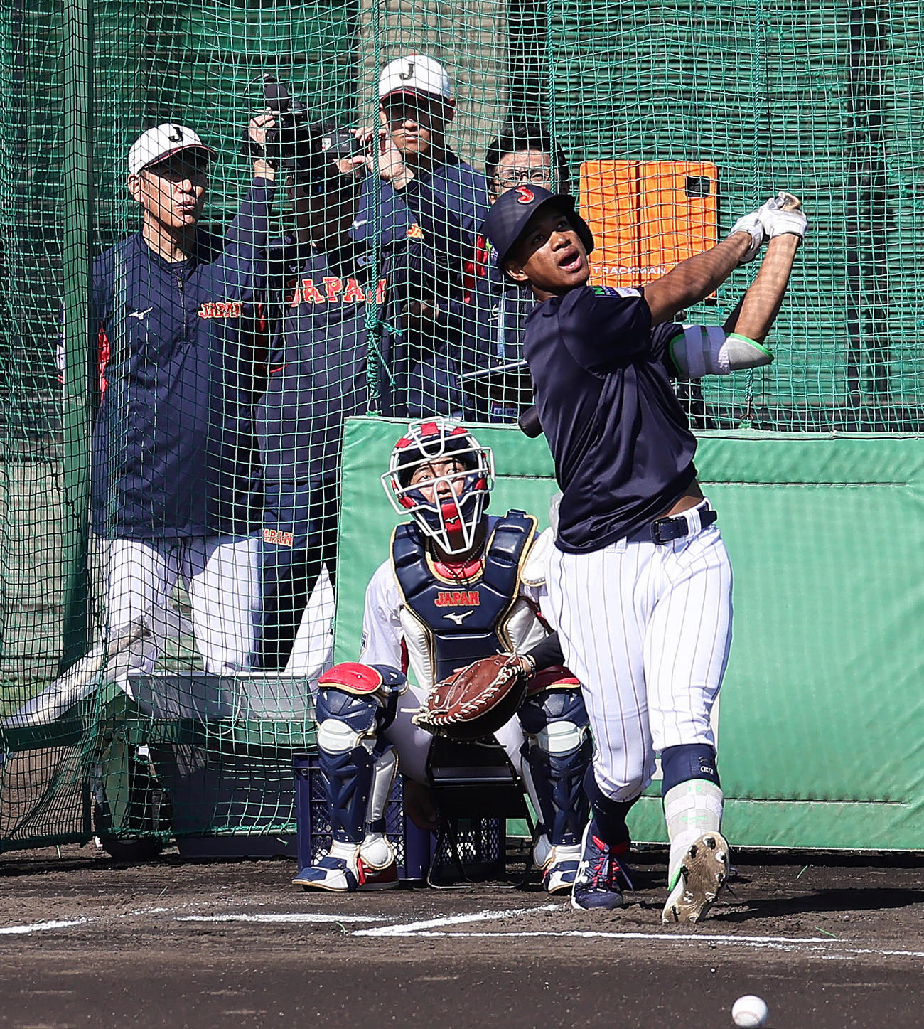 井端監督（左）が見つめる中、フリー打撃で柵越えの当たりを放つ万波（撮影・足立雅史）