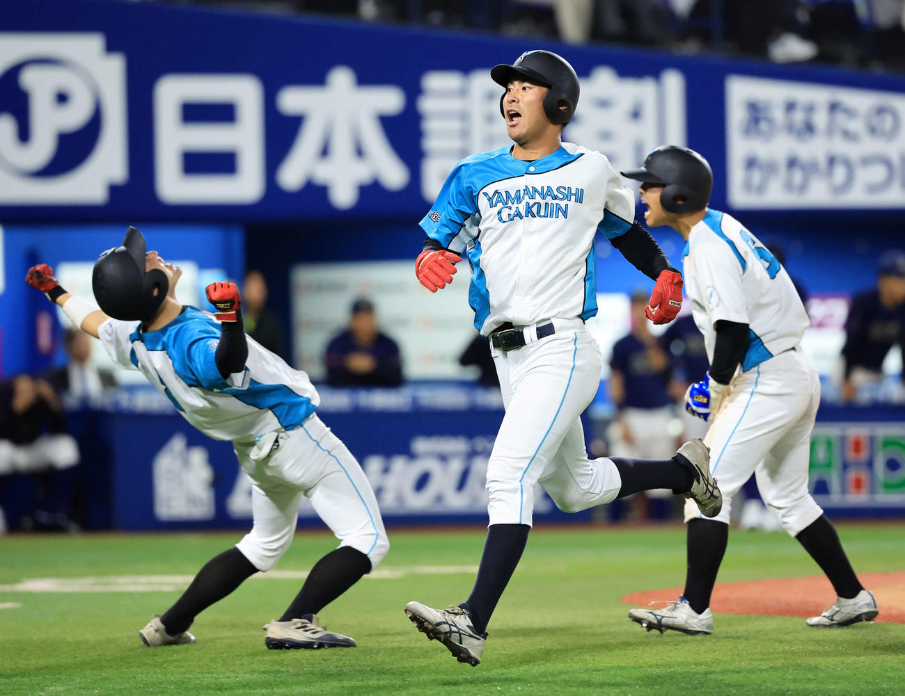 山梨学院大対創価大　10回表山梨学院大無死満塁、山元の適時二塁打で生還した宮崎（手前）は雄たけびを上げる（撮影・浅見桂子）