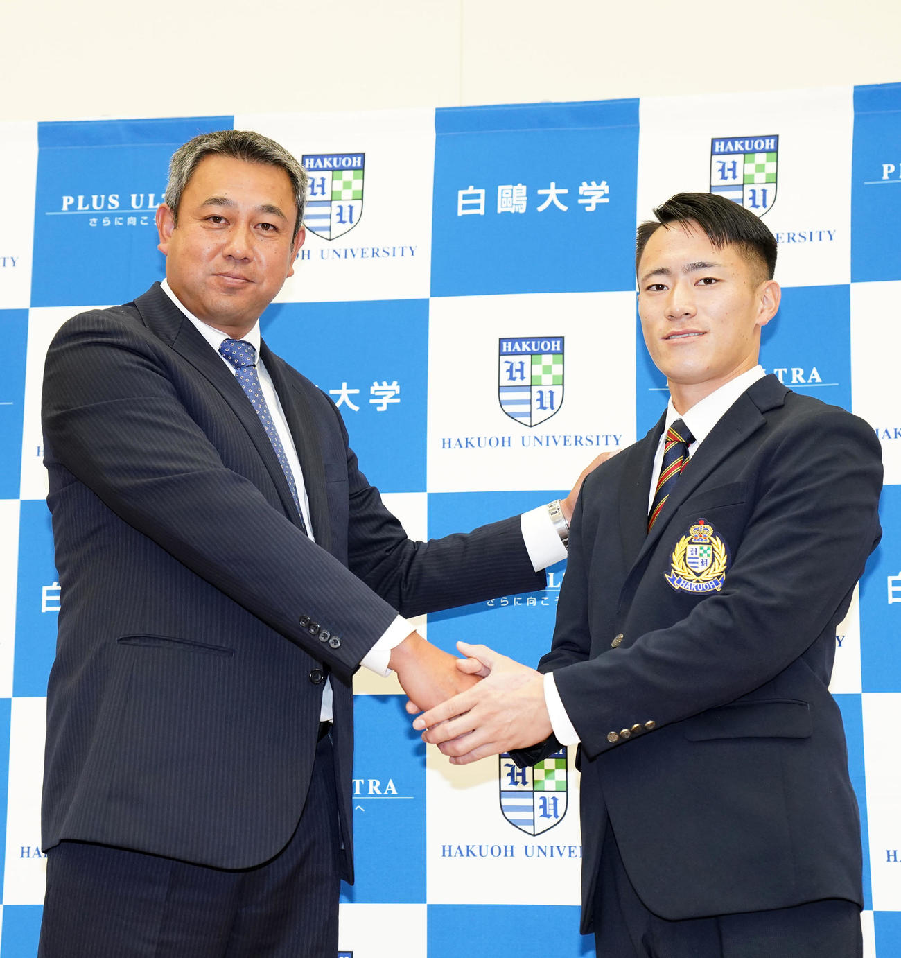 握手を交わす白鴎大・福島（右）と藤田監督（撮影・横山健太）