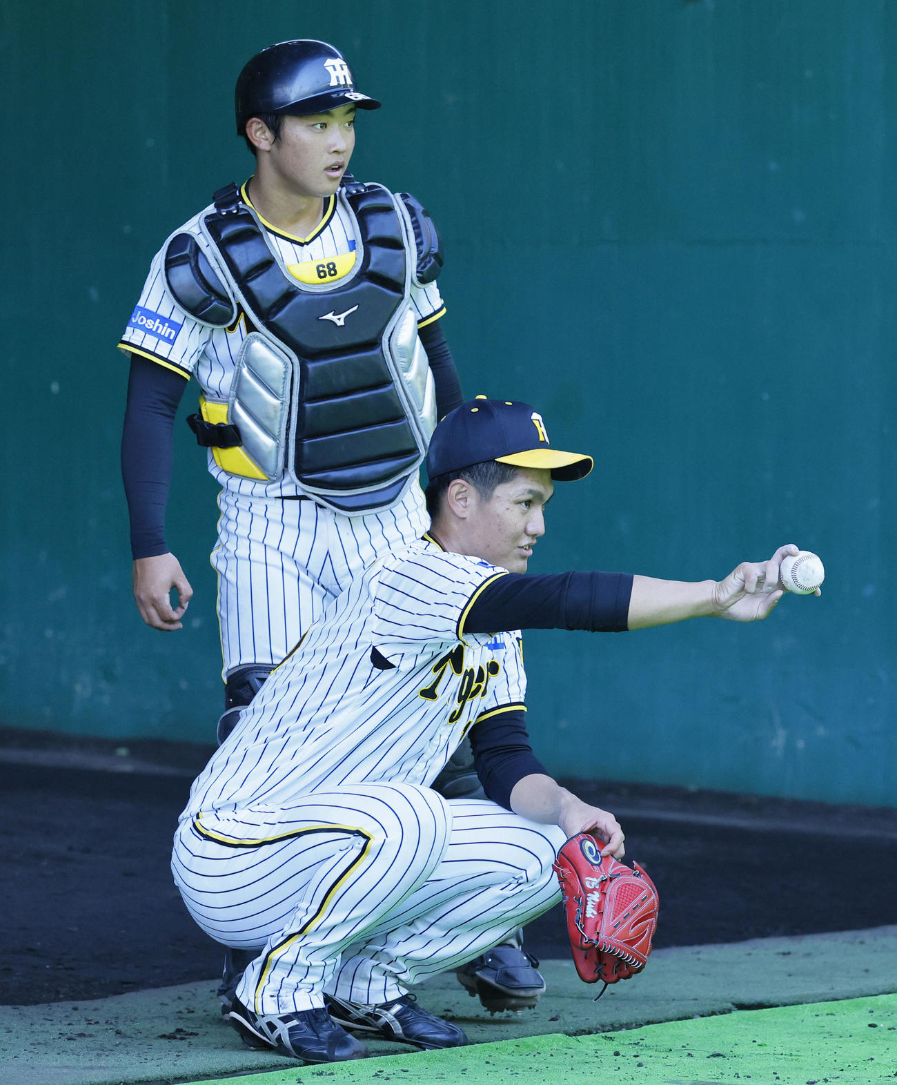 阪神秋季キャンプ　ブルペンでの投球練習を終え、中川勇斗（奥）と話をする阪神西純（撮影・藤尾明華）
