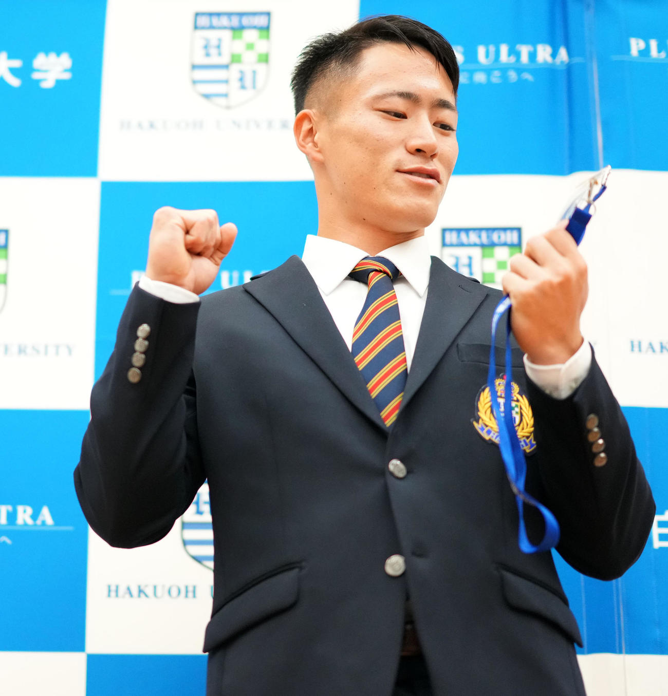 阪神岡田監督のサインが入ったドラフト指名券を嬉しそうに見つめる白鴎大・福島（撮影・横山健太）