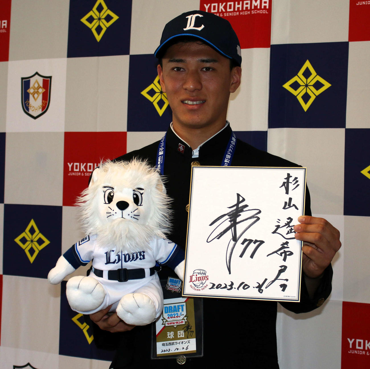 西武から指名あいさつ後に球団からのプレゼントを手に笑顔を見せるドラフト3位の横浜・杉山遥希投手（撮影・木下大輔）