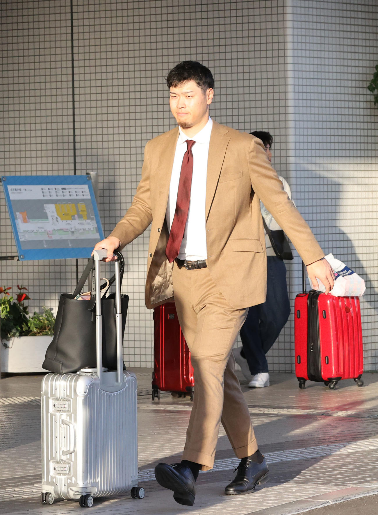空路で宮崎入りした佐藤輝は移動のタクシーへ向う（撮影・梅根麻紀）