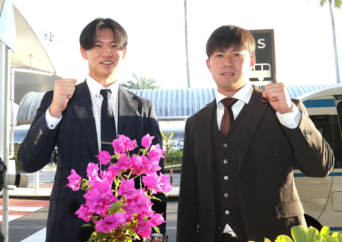 宮崎に到着し、ブーゲンビリアの花を前に笑顔を見せる阪神の及川（左）と桐敷（撮影・足立雅史）