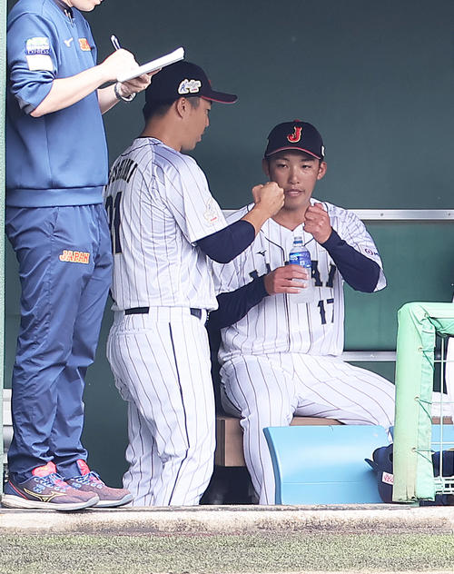 侍ジャパン対巨人　3回1失点の侍ジャパン赤星（右）は吉見投手コーチとタッチを交わす（撮影・足立雅史）