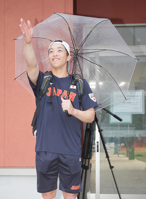 先に出発した移動バスに笑顔で手を振る岡林（撮影・足立雅史）