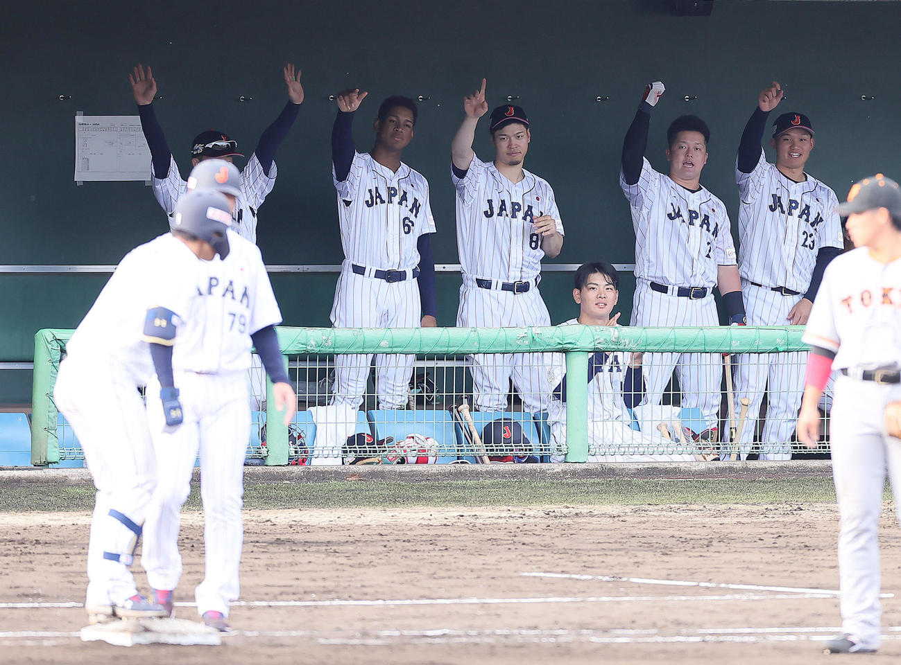 侍ジャパン対巨人　タイブレーク練習の10回表侍ジャパン1死一、二塁、藤原（手前左端）の左前打に盛り上がるベンチ。後方左から万波、佐藤輝、野村、牧、森下（撮影・足立雅史）