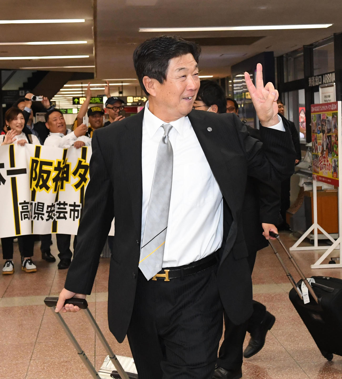 Vサインで高知入りした平田ヘッドコーチ（撮影・前岡正明）