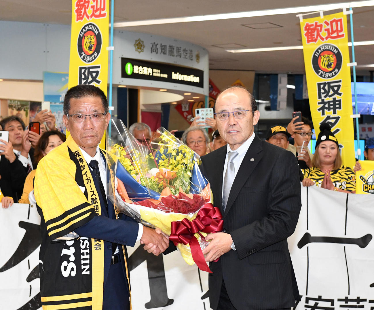 高知龍馬空港での歓迎セレモニーで花束を受け取った阪神岡田監督（右）（撮影・前岡正明）
